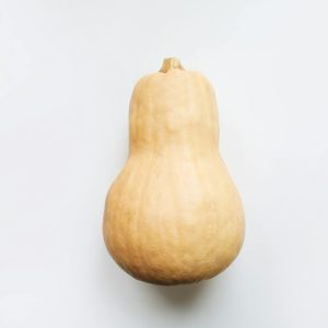 Minimalist image of a butternut squash with a focus on its natural texture and color.
